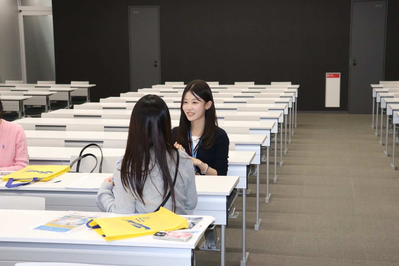 講義室の机を挟んで会話する様子