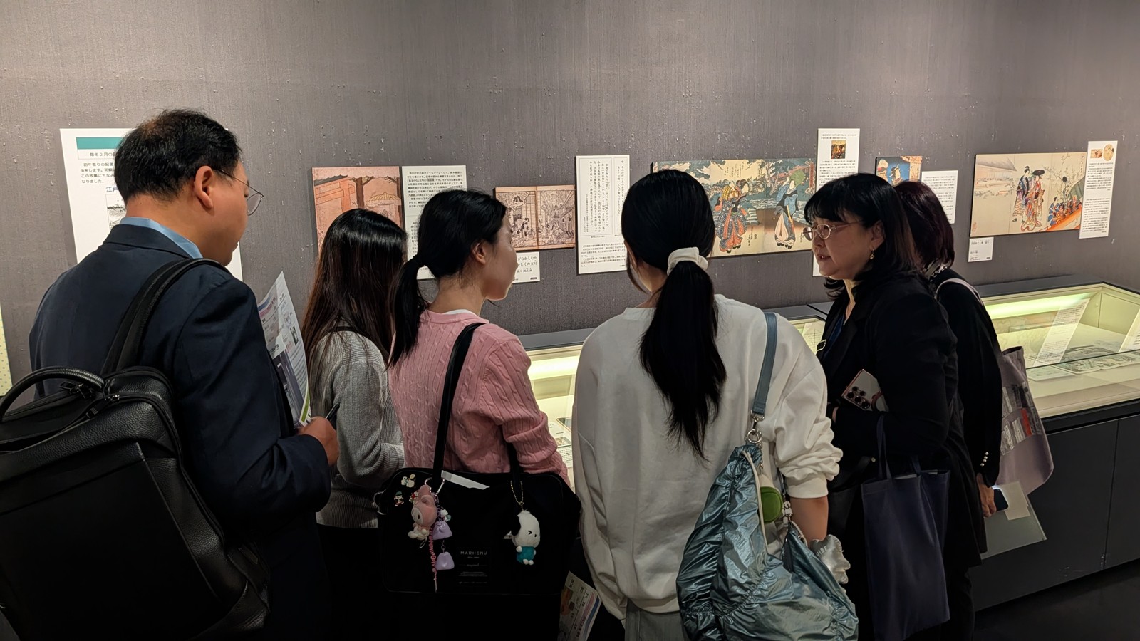 展示を見ながら説明を聞く訪問者の様子